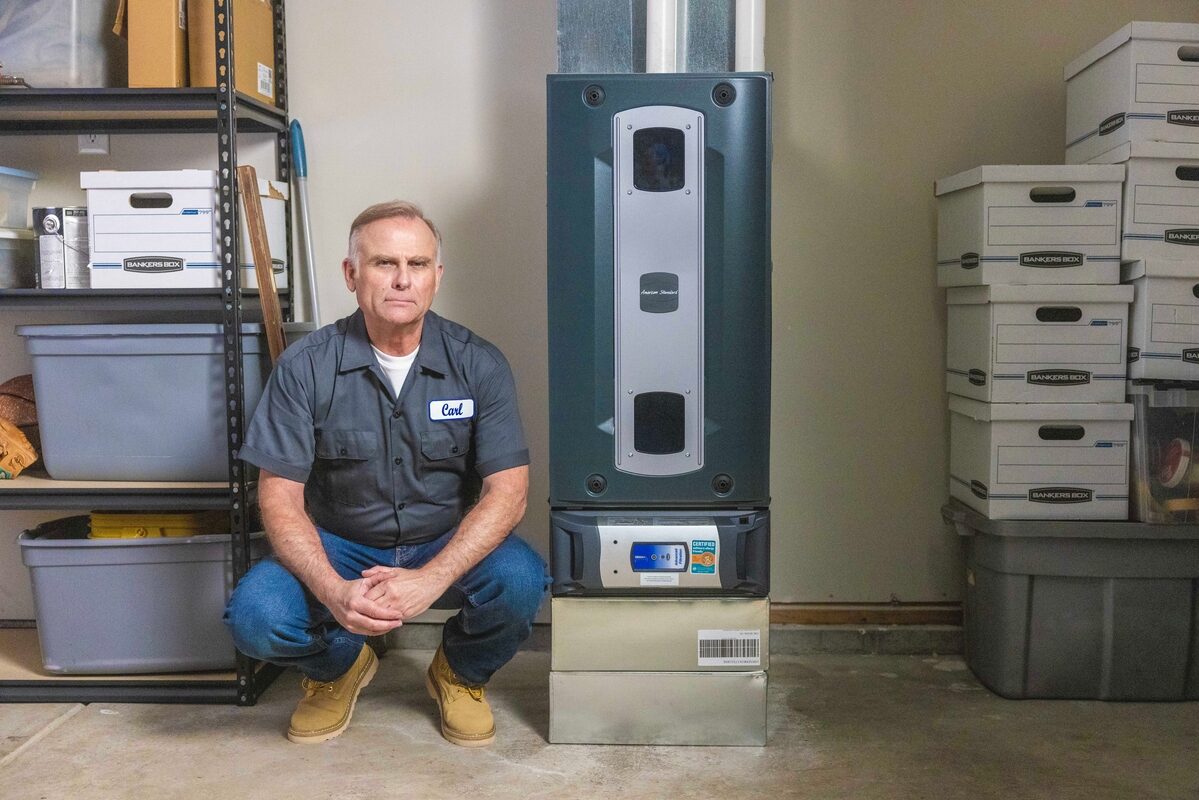 hvac technician posing with a furnace