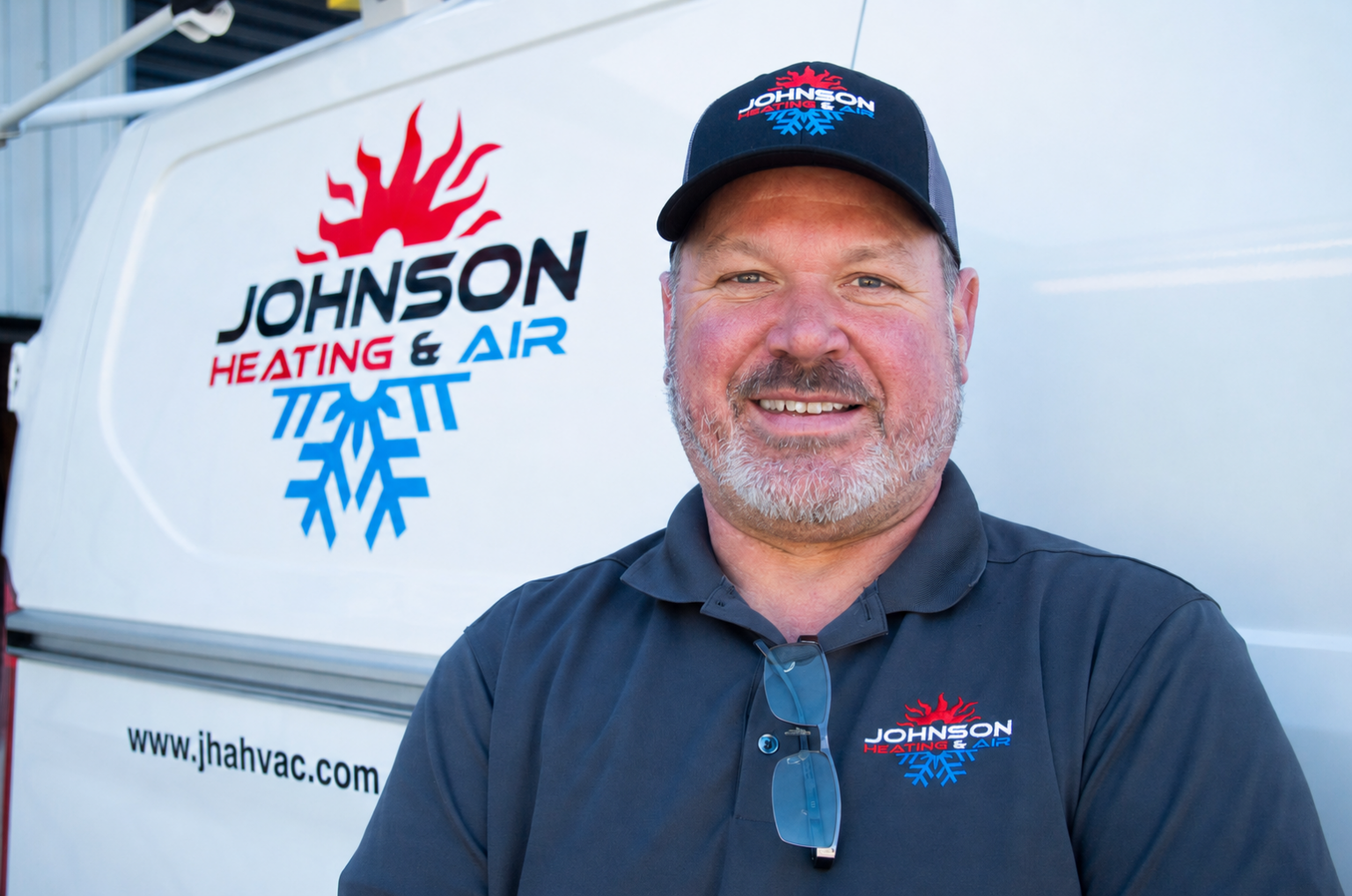 Johnson Heating & Air Conditioning service technician standing beside company van